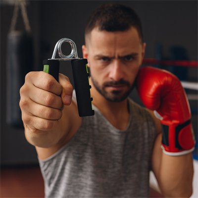 boxeur s'exerce avec le hand grip pour renforcer ses maisn