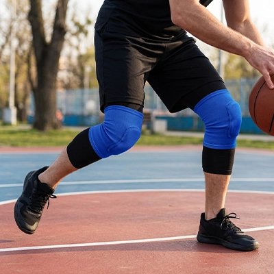 homme joue au basket avec Genouillère pour le sport​ 